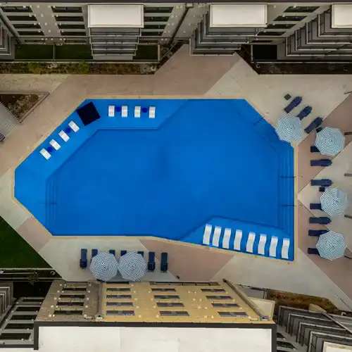 Drone downshot perfectly framing a large apartment building's pool