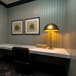 Private desk warmly lit by a brass lamp in a shared work space facility.